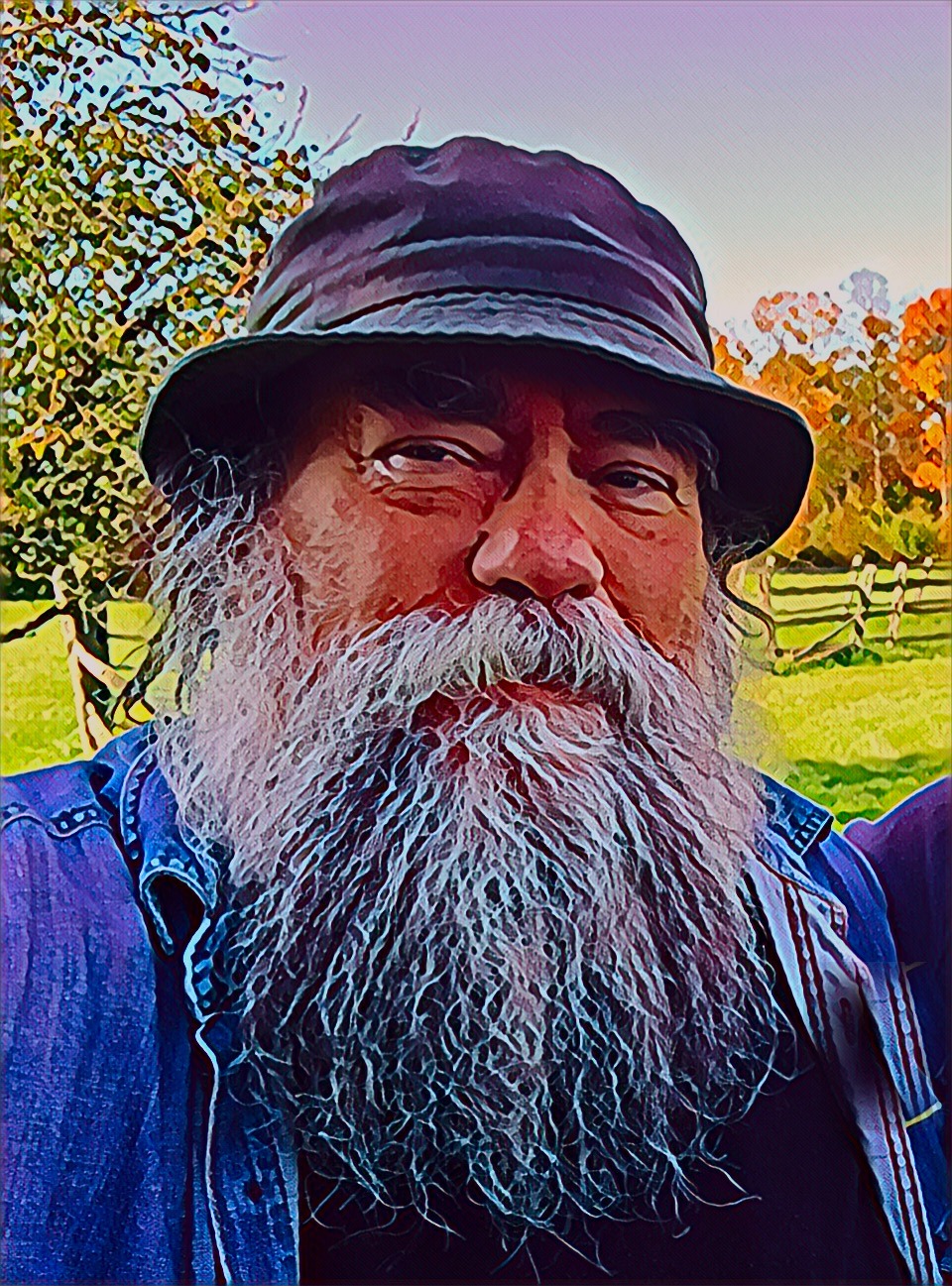 Jim 'Bear' Katona — bucket hat, full white beard, denim shirt, autumn trees behind him